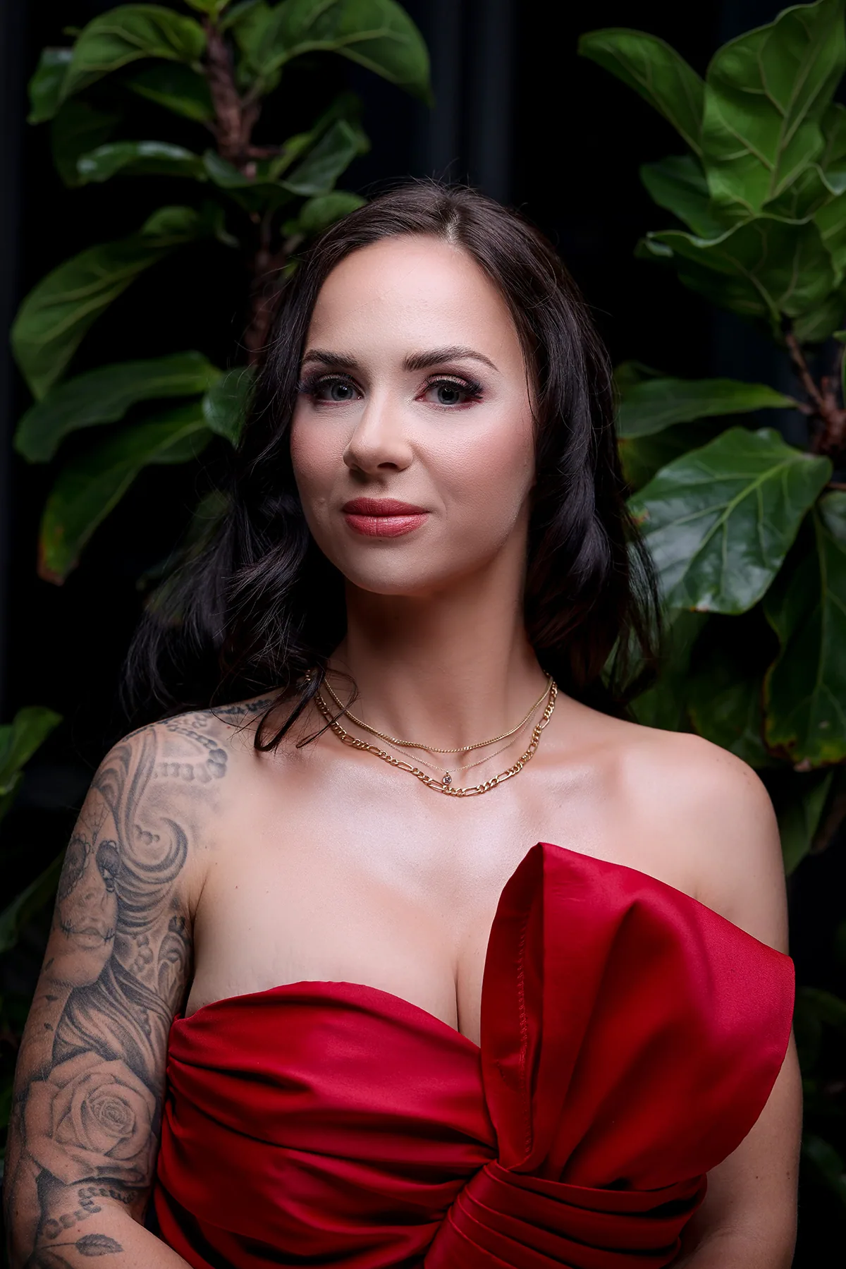 Editorial red-carpet makeup look by Haleh, face framed against deep green foliage